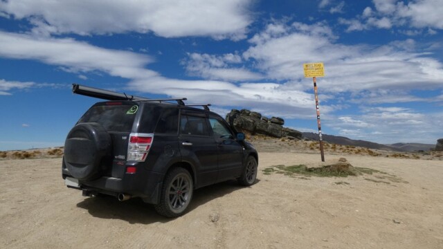 Parked up at the top of the Nevis Road beside the road sign. At the top of the Nevis Road. The highest public road in New Zealand. With the road sign beside teh Suzuki Escudo and some rock formations in the background