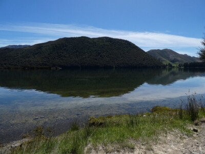 More of Loch Katrine and its clear water with the camp ground to the right Loch Katrine and its clear water with a tree covered hill in the back ground, and the cam ground to the right.